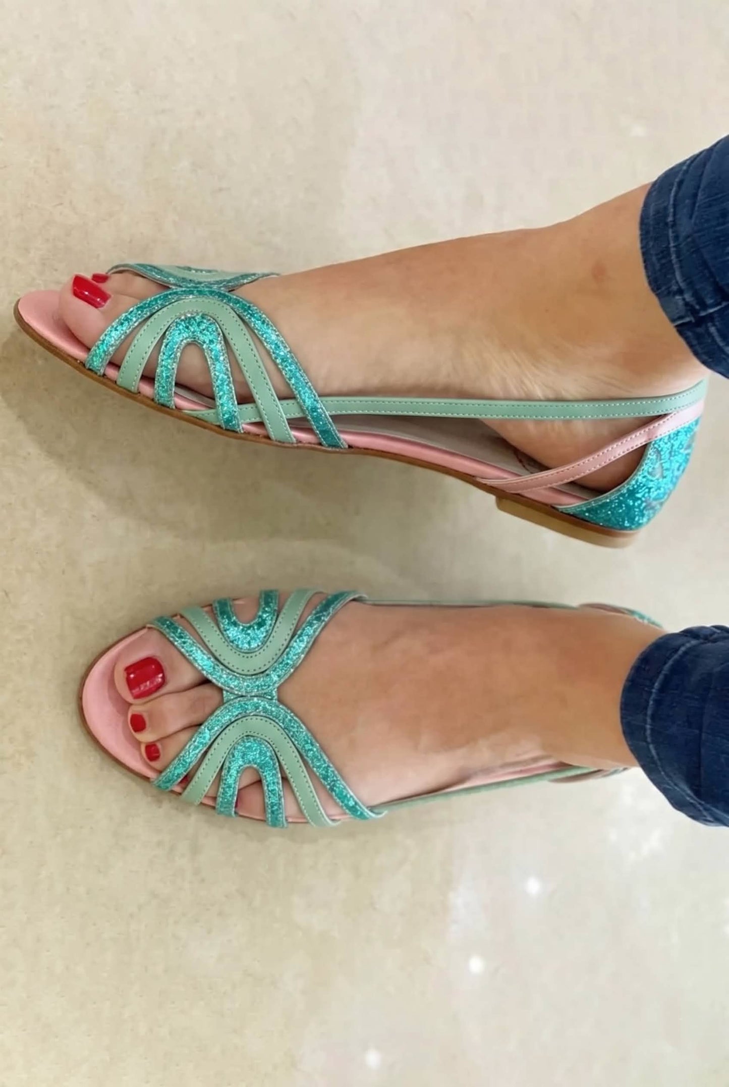 Sandalias turquesa brillantes con tiras en abanico y punta abierta, tacón bajo.