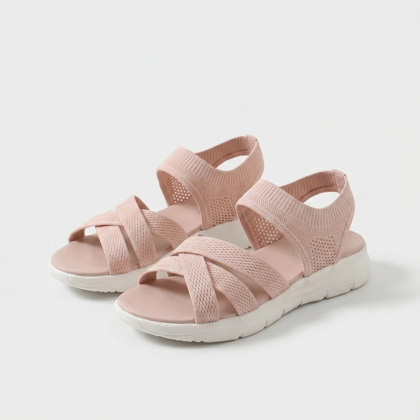 Sandalias ortopédicas rosadas con tiras cruzadas de tejido y suela blanca gruesa