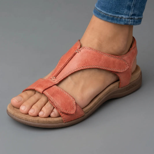 Sandalia ortopédica ergonómica de piel color salmón, con tira ajustable y suela marrón.