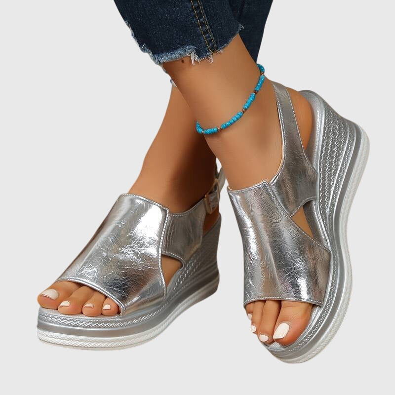 Sandalias ortopédicas plateadas con plataforma y talón abierto, con pulsera azul