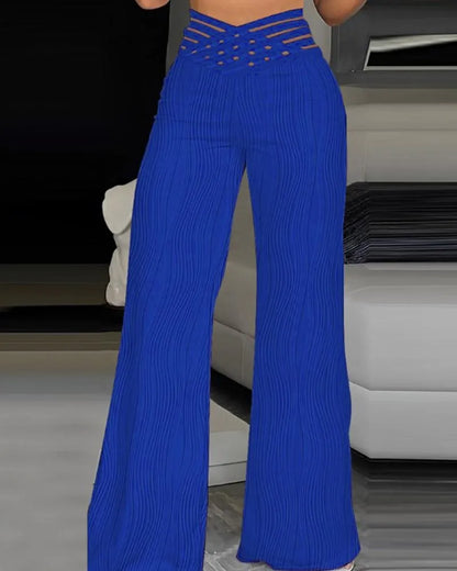 Pantalones azules de cintura alta cruzados, con rayas verticales onduladas y pierna acampanada