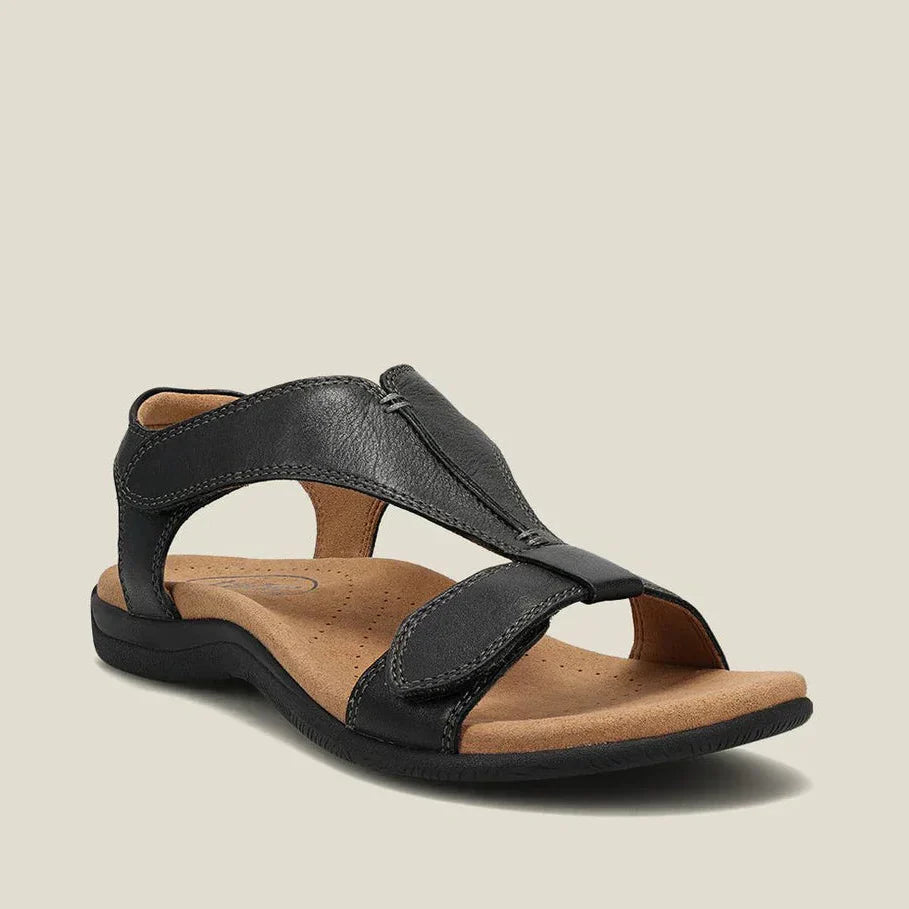 Sandalias ergonómicas negras de piel con tira central y cierre ajustable.
