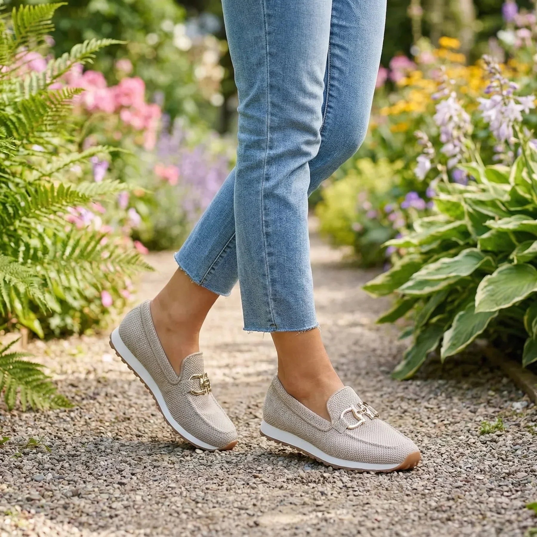 Zapatillas tipo mocasín Chiara grises con hebilla metálica dorada y suela beige.