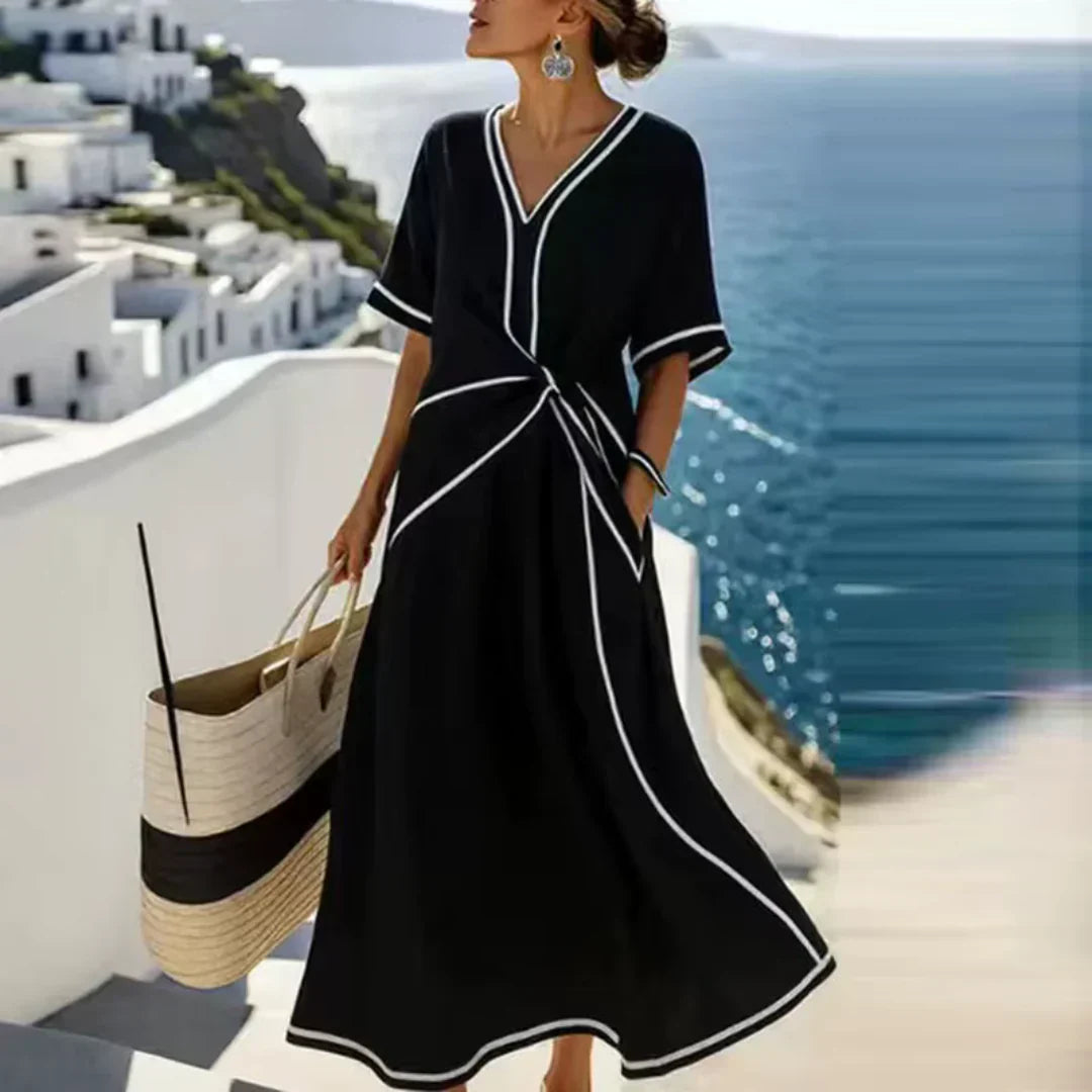 Vestido midi negro con escote en V y ribete blanco, lazo fruncido en la cintura