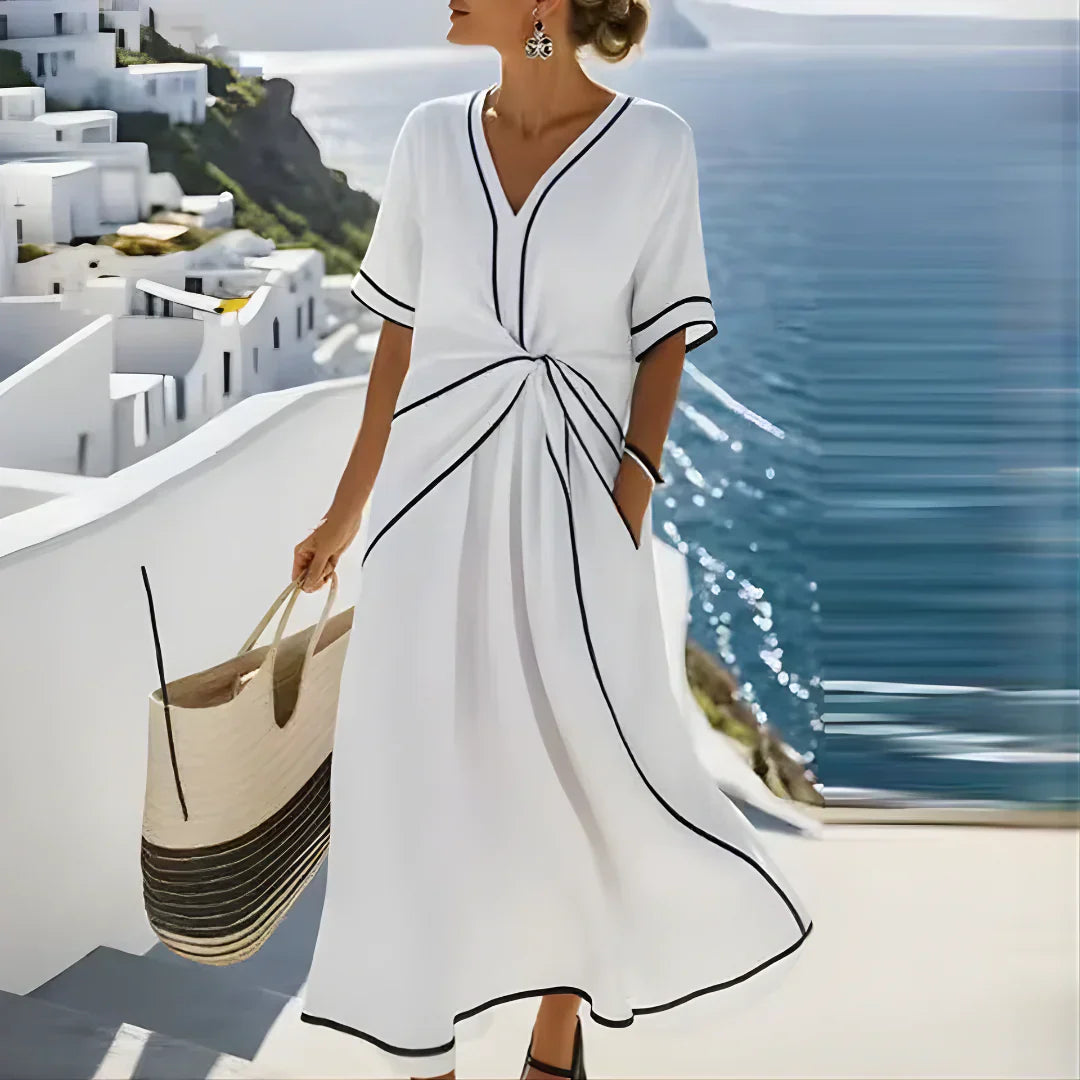 Vestido midi blanco con escote en V y ribete negro, lazo fruncido en la cintura
