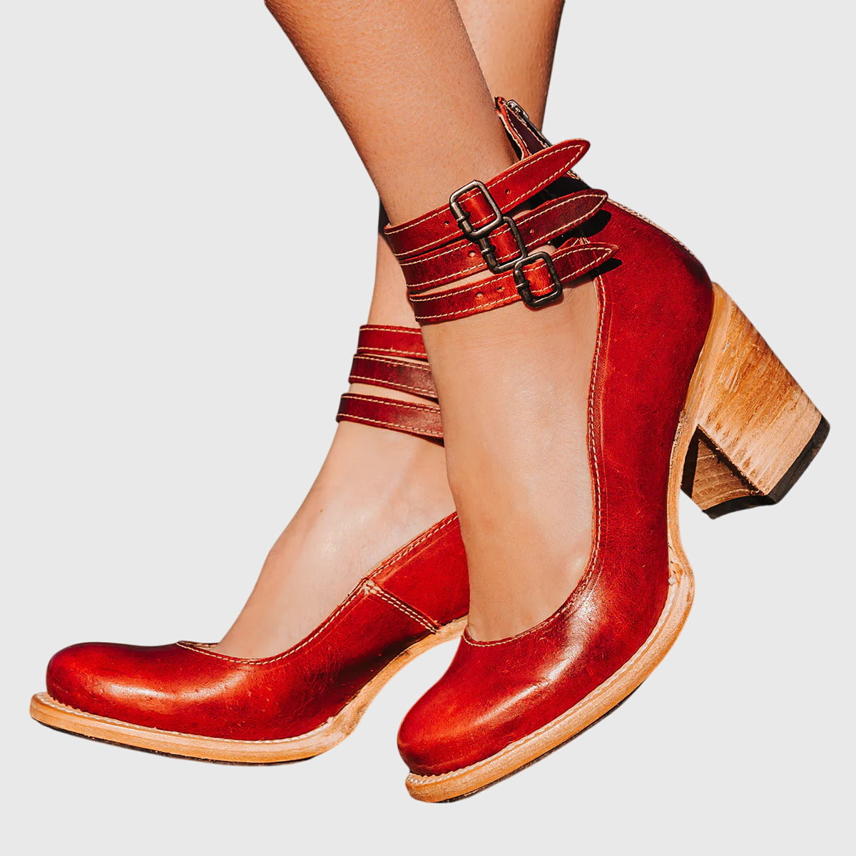 Zapatos de tacón burdeos de charol con doble hebilla en el empeine.