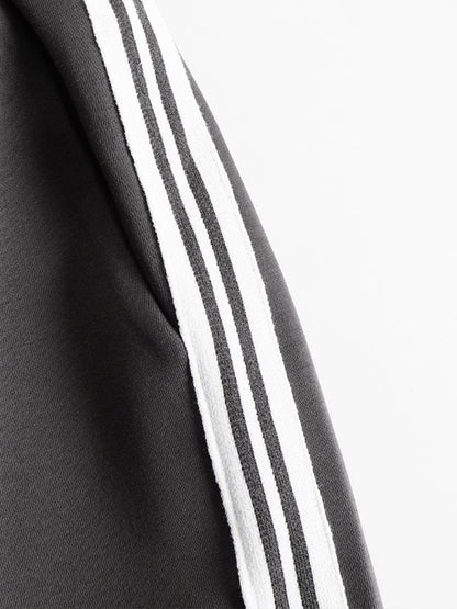 Detalle lateral de sudadera gris con dos rayas blancas en el tejido