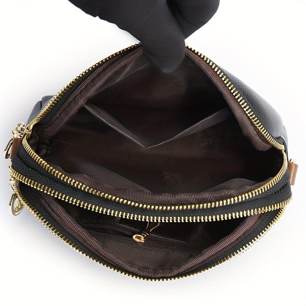 Interior del bolso de hombro negro con cremallera y forro, vista desde la apertura.