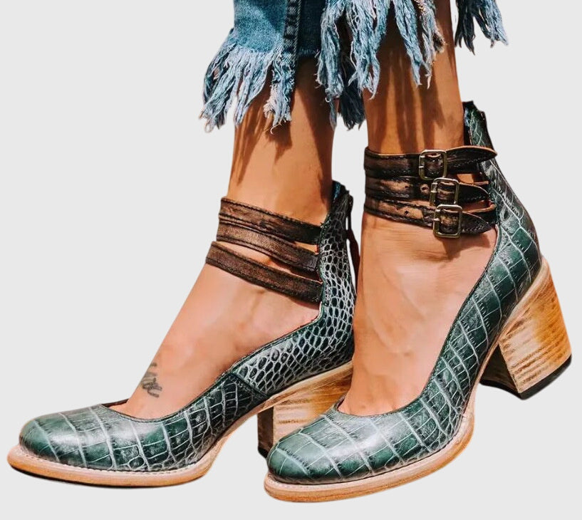 Zapatos de tacón verde con estampado tipo cocodrilo y doble hebilla en el empeine.
