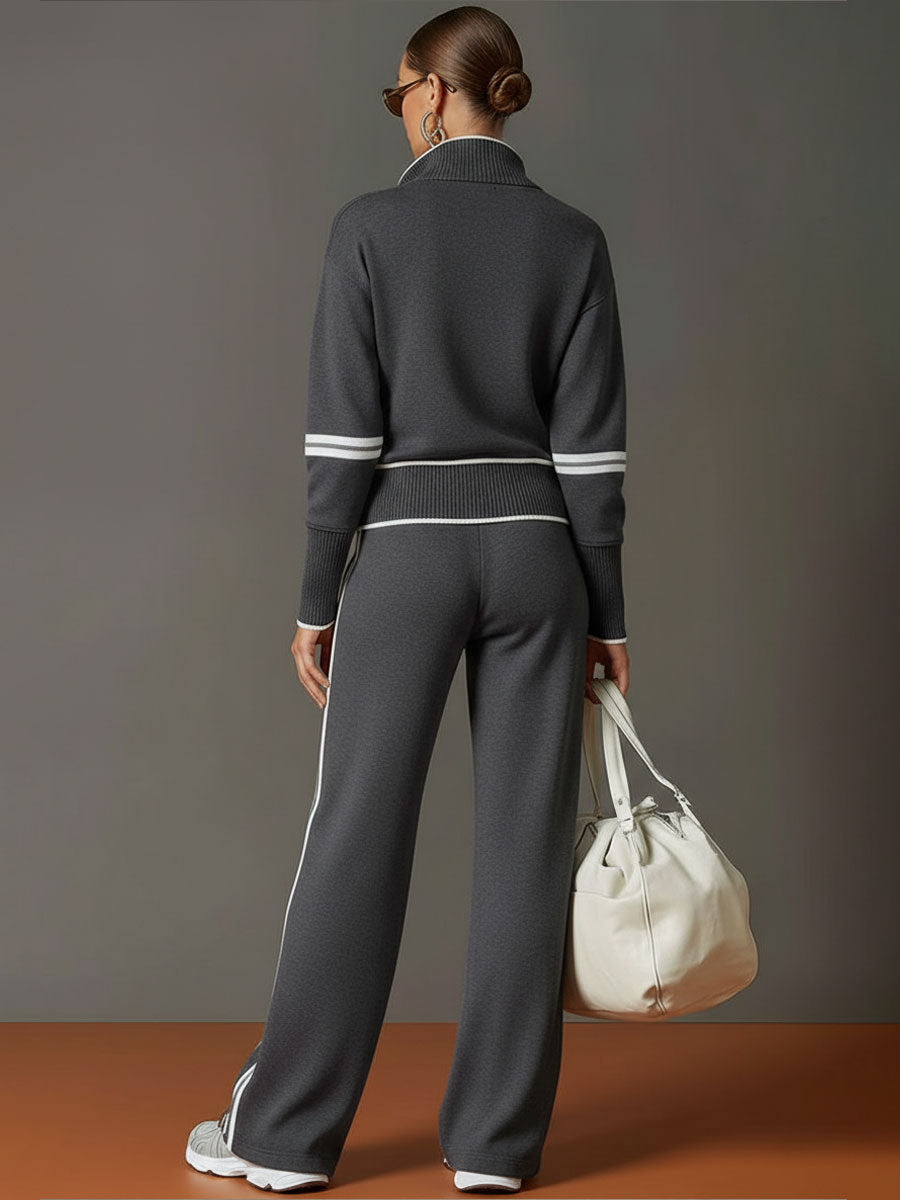 Conjunto deportivo negro visto por detrás: sudadera de cuello alto y pantalón ancho a rayas