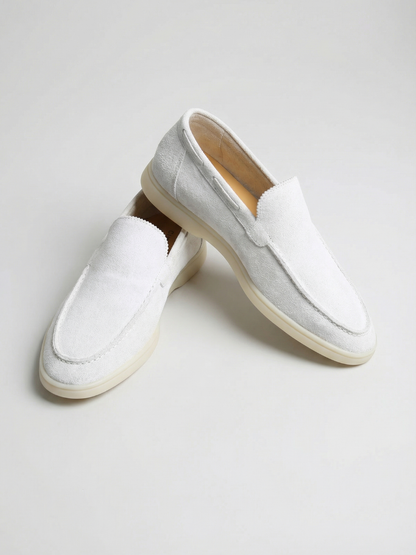 Mocasines de ante color blanco, con panel frontal acolchado y suela clara.