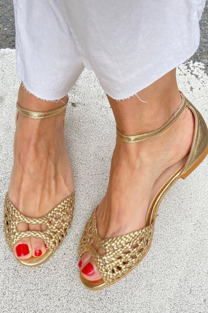 Sandalias doradas de punta abierta con trenzado y pulsera metálica al tobillo
