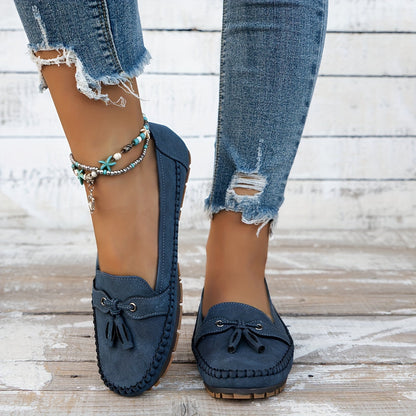 Mocasines azules de gamuza con borlas y lazo frontal; suela de goma, puestos