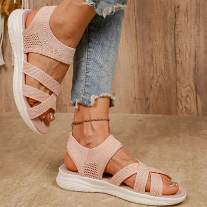 Sandalias ortopédicas rosa con tiras entrelazadas, malla perforada y suela blanca