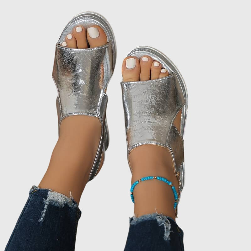 Sandalias ortopédicas plateadas con talón abierto y pulsera azul de cuentas