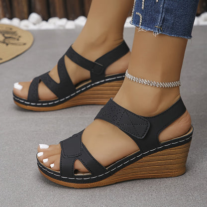 Sandalias ortopédicas negras de cuña con tiras cruzadas y costuras blancas