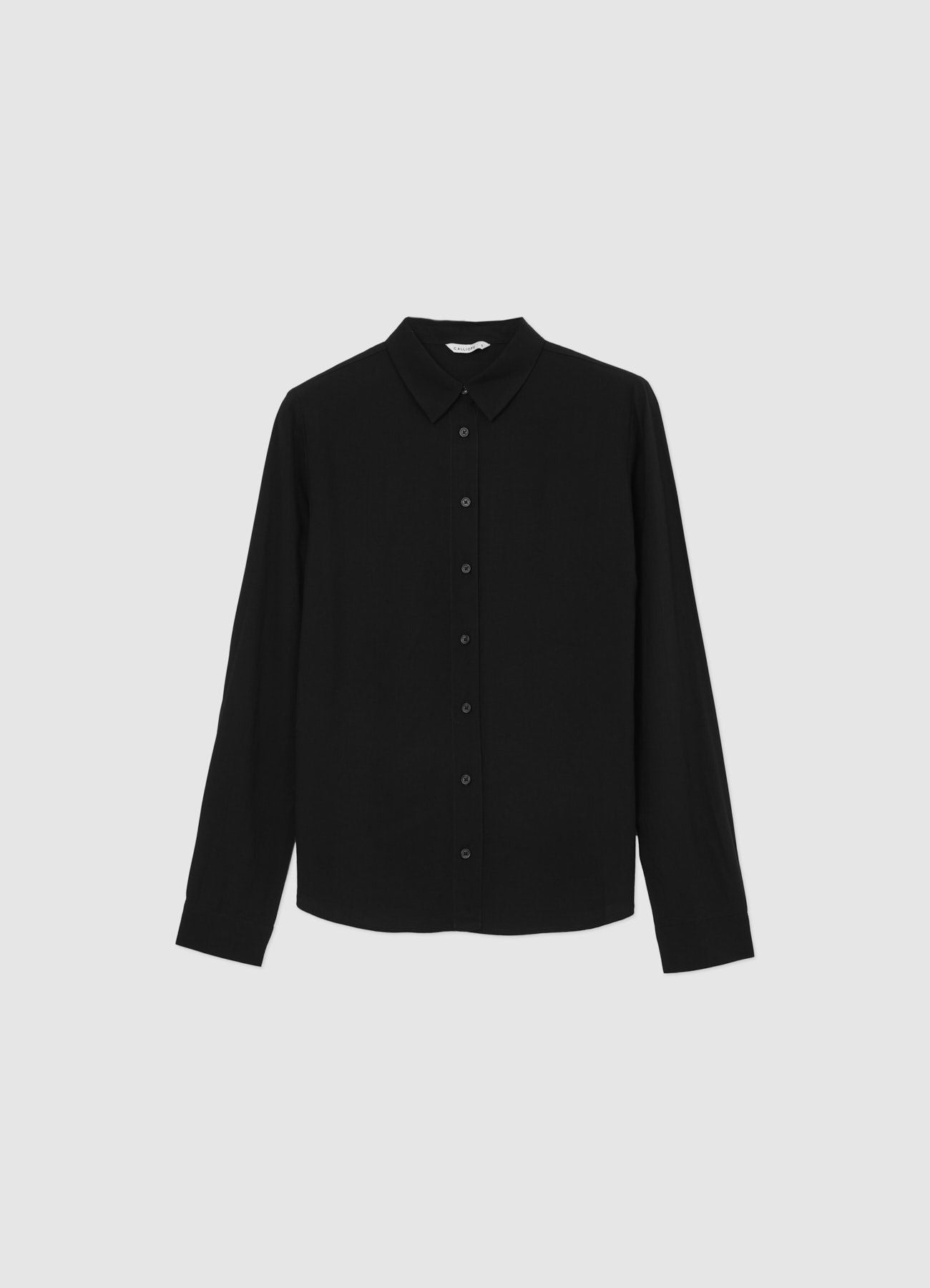 Camisa negra lisa de manga larga, cuello con botones, vista frontal.
