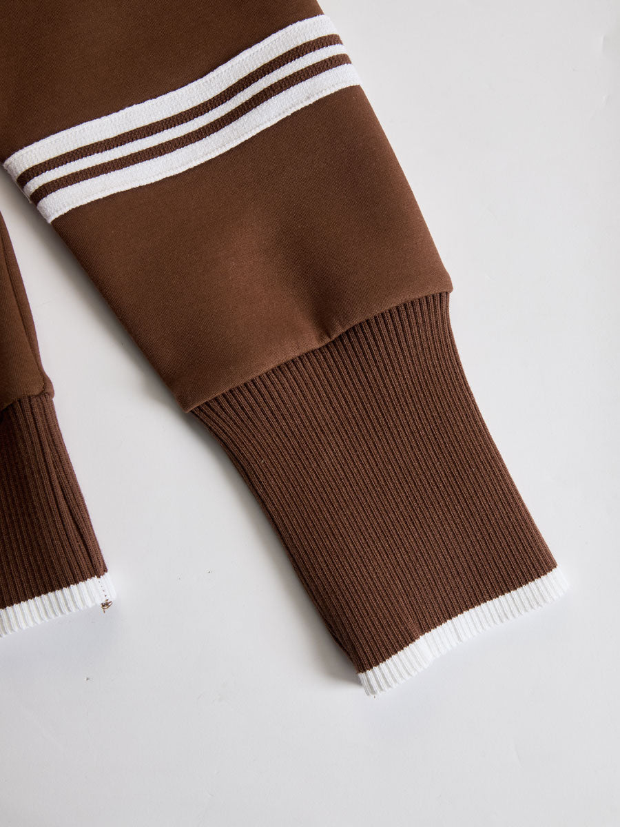 Bajo de pantalón marrón con franja blanca y puño acanalado