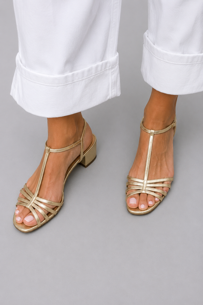 Sandalias doradas de tacón bajo con tiras cruzadas y cierre en el talón