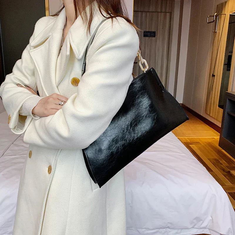Bolso de hombro de cuero negro tipo sobre con asa superior y correa