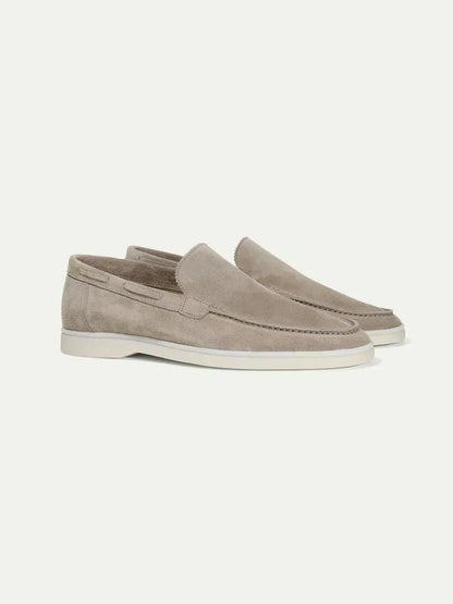 Mocasines de ante color beige topo, estilo slip-on, suela blanca y costuras.