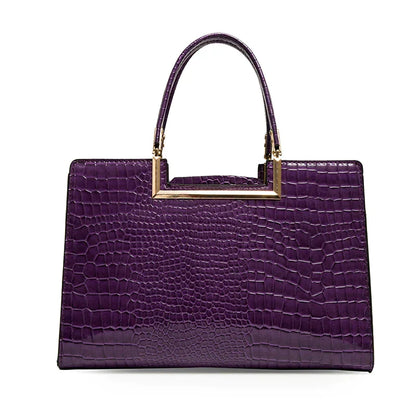 Bolso de cuero morado con asa superior y acabado tipo cocodrilo