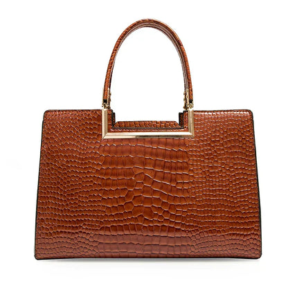 Bolso de cuero marrón con asa superior metálica, textura tipo cocodrilo y cartera a juego