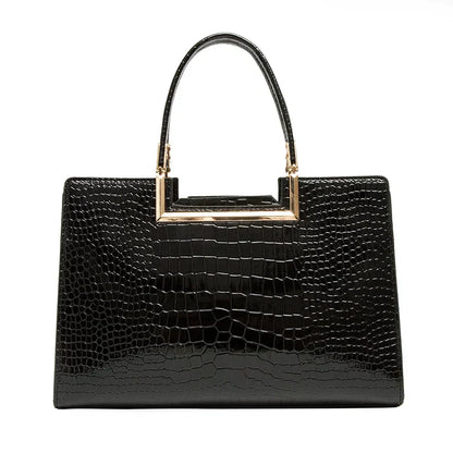 Bolso de cuero negro con asa superior metálica, textura tipo cocodrilo y cartera a juego