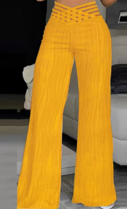 Pantalones amarillos de cintura alta cruzados, con rayas verticales onduladas y pierna acampanada