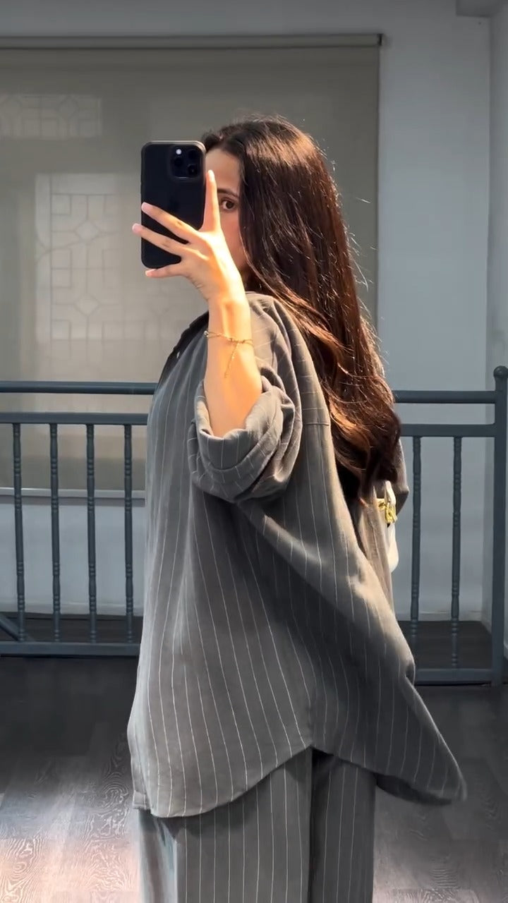 Conjunto suelto de dos piezas gris con chaqueta abierta y pantalón de rayas verticales
