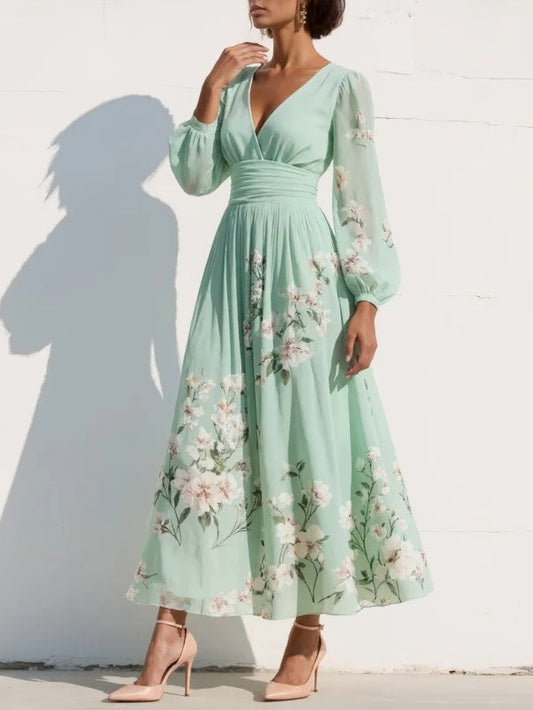 Vestido largo de gasa verde menta con estampado floral, escote pico y mangas globo.