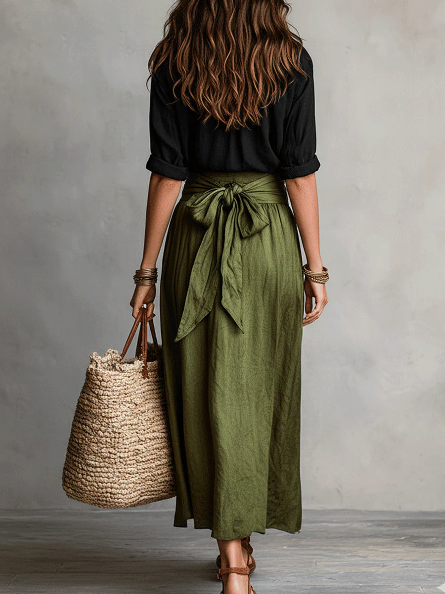 Conjunto de dos piezas visto por detrás: camisa negra y falda midi verde oliva con nudo