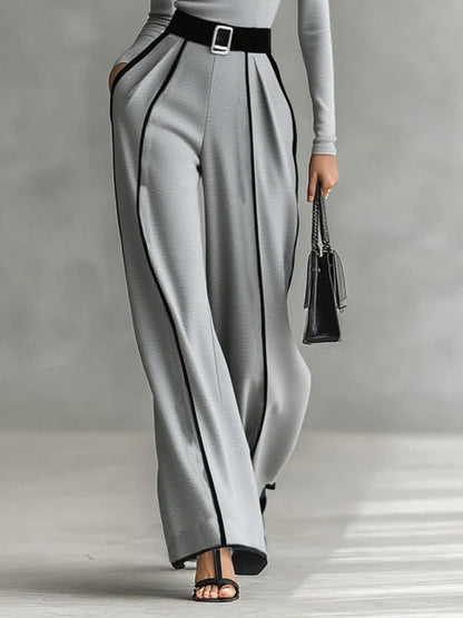 Conjunto gris de cuello alto con cinturón y pantalón ancho; ribetes oscuros verticales