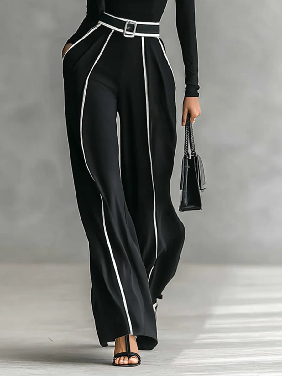 Conjunto negro con pantalón de pierna ancha y ribetes blancos; cinturón con hebilla