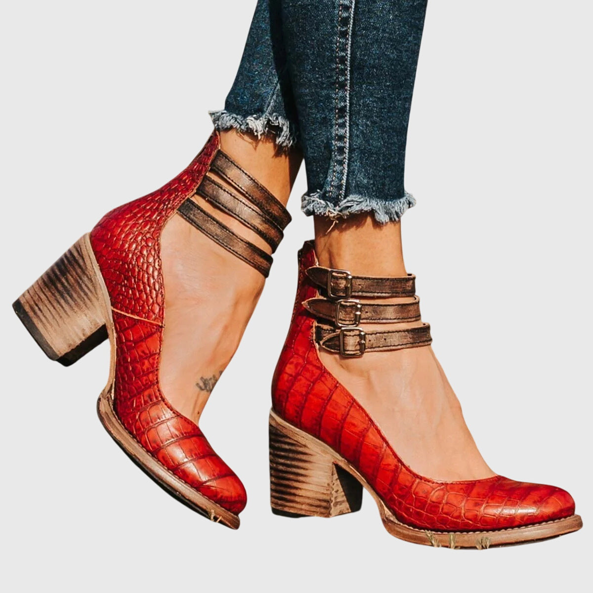 Zapatos de tacón rojos tipo cocodrilo con doble hebilla y tacón ancho.