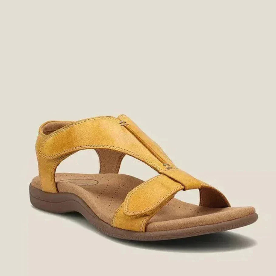 Sandalias ortopédicas de ante color amarillo, con tira ajustable y suela acolchada.