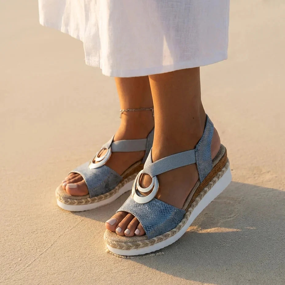 Sandalia ortopédica azul claro con hebilla plateada, suela de cuña yute y blanca