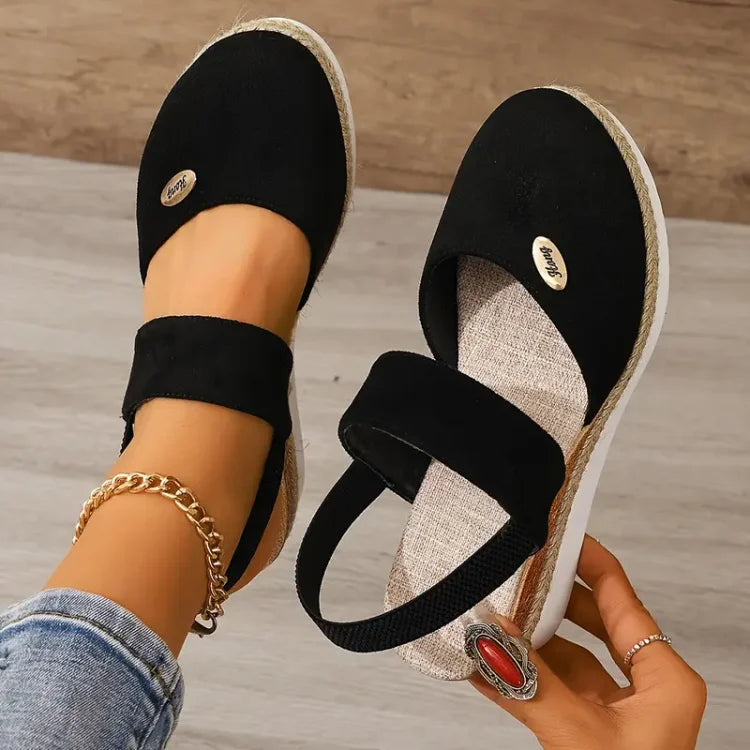 Sandalias negras tipo cuña con tiras cruzadas y suela de yute, con detalle oval
