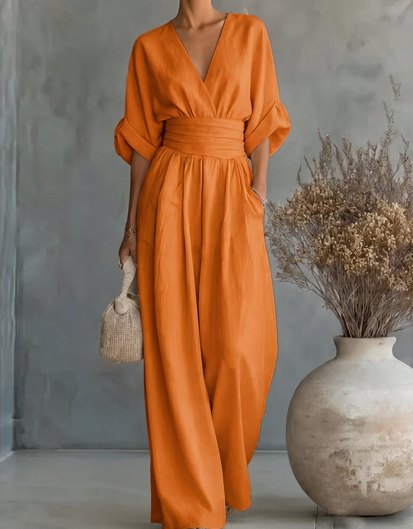Mono largo naranja con escote en V y pierna ancha, fruncido a la cintura y mangas kimono.