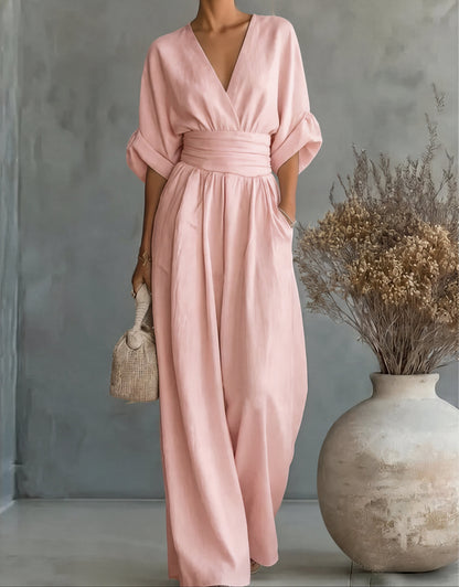 Mono largo rosa claro con escote en V y pierna ancha, cinturón fruncido y mangas tipo kimono.