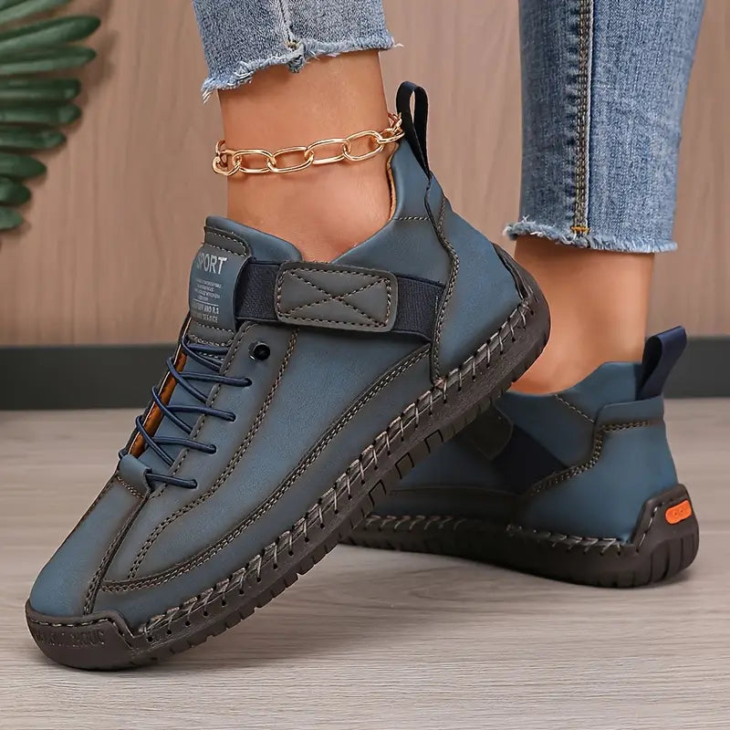 Zapatillas ortopédicas azules con cordones, detalle negro y suela resistente con tacos.
