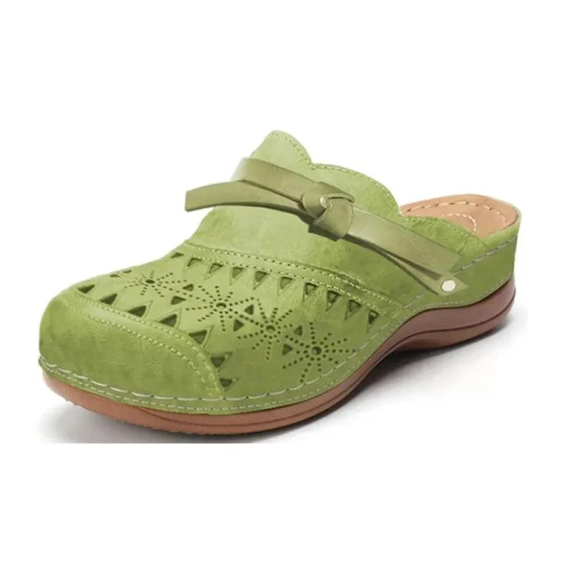 Zueco ortopédico verde claro con perforaciones, tira ajustable y suela de cuña marrón