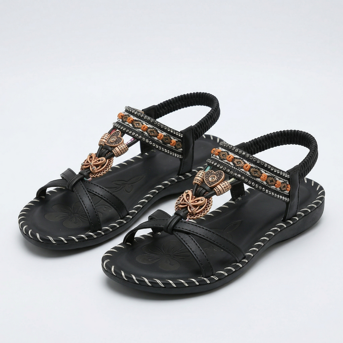 Sandalias ortopédicas estilo Ibiza negras con tiras elásticas y adorno dorado con pedrería.