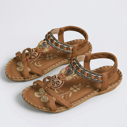 Sandalias ortopédicas Ibiza camel con tiras marrón, adorno dorado y pedrería multicolor.
