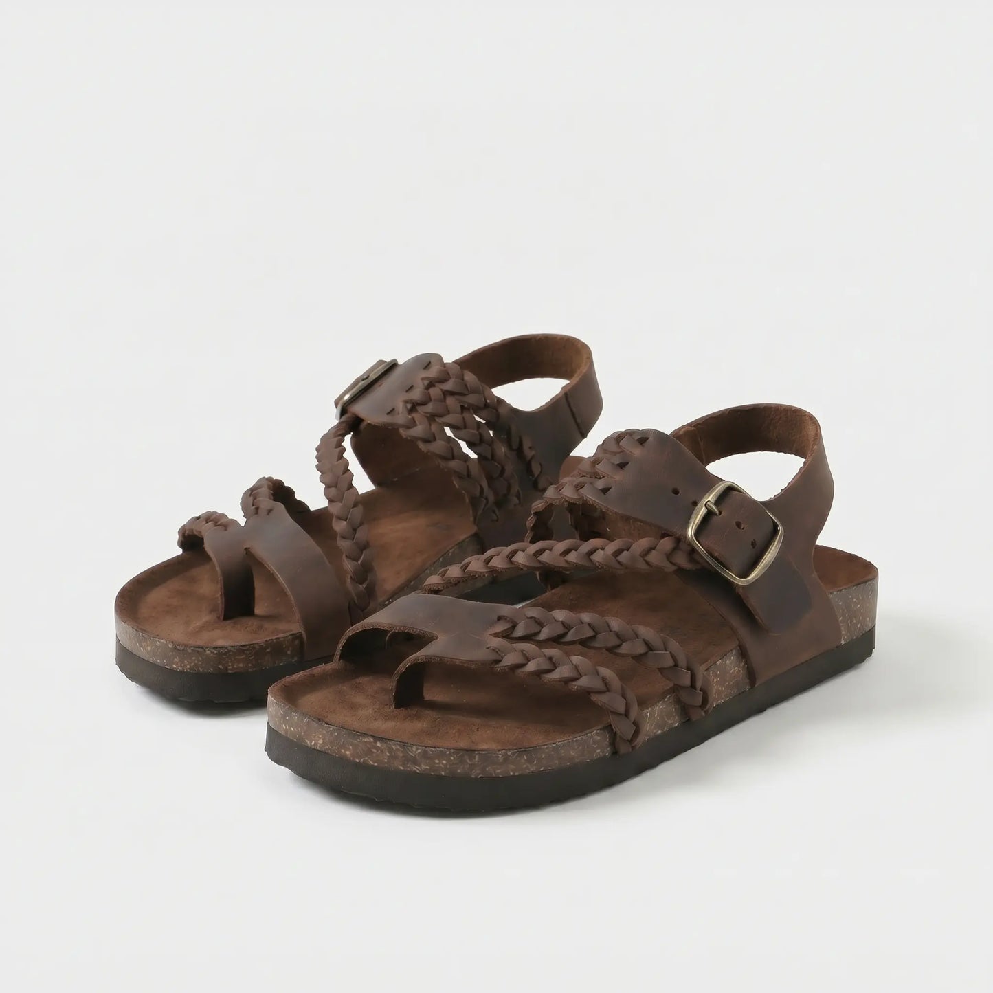 Sandalias anatómicas marrón oscuro con trenzado y hebilla metálica ajustable.