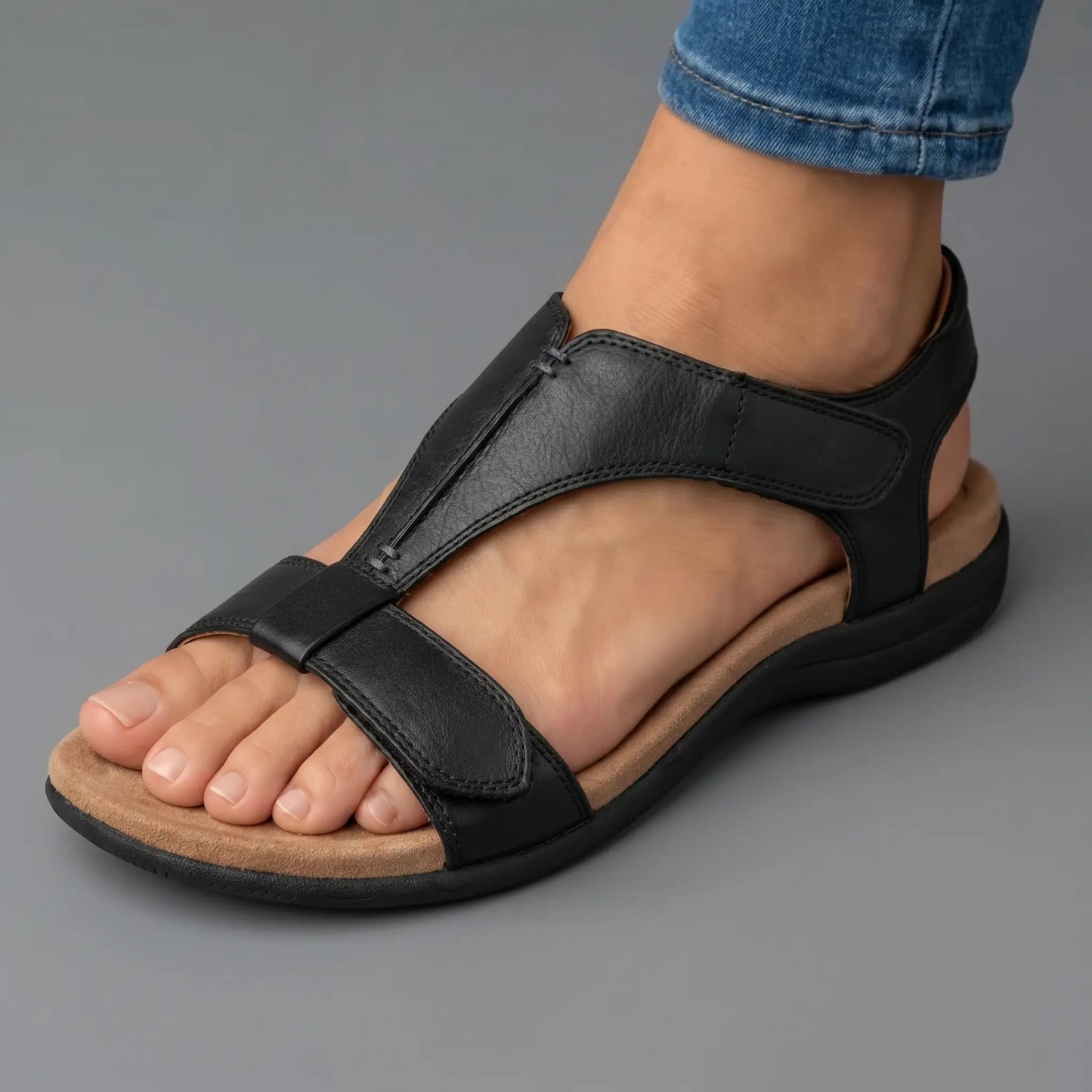 Sandalia ortopédica ergonómica negra de piel, con tira ajustable y suela oscura.