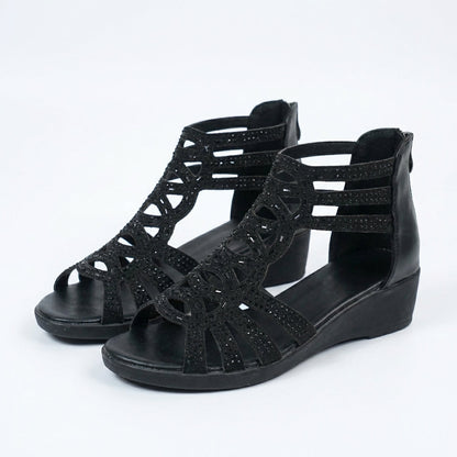 Sandalias negras con tiras troqueladas y plataforma baja, diseño abierto tipo bota