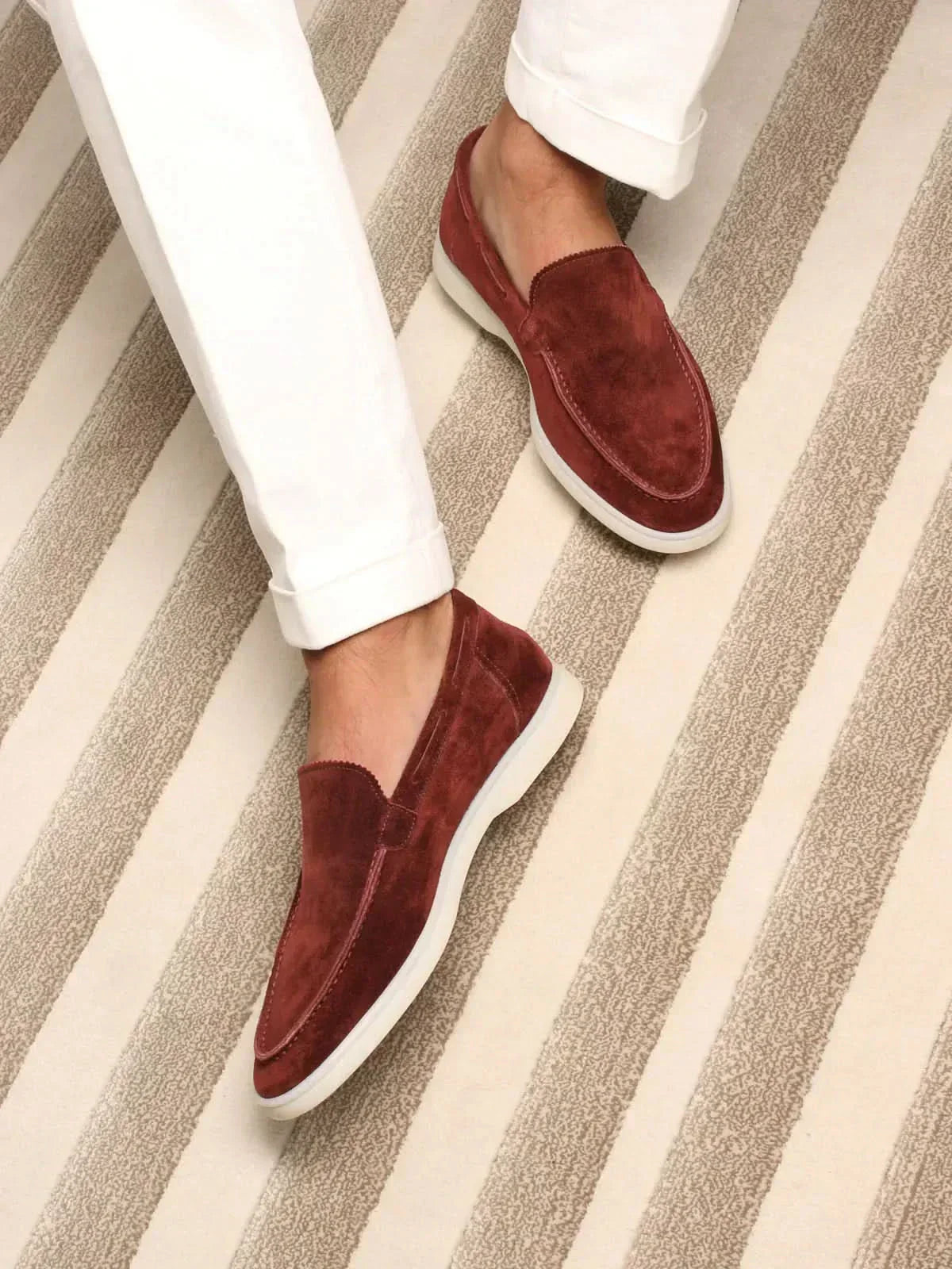 Mocasines de ante burdeos, slip-on, con suela blanca.
