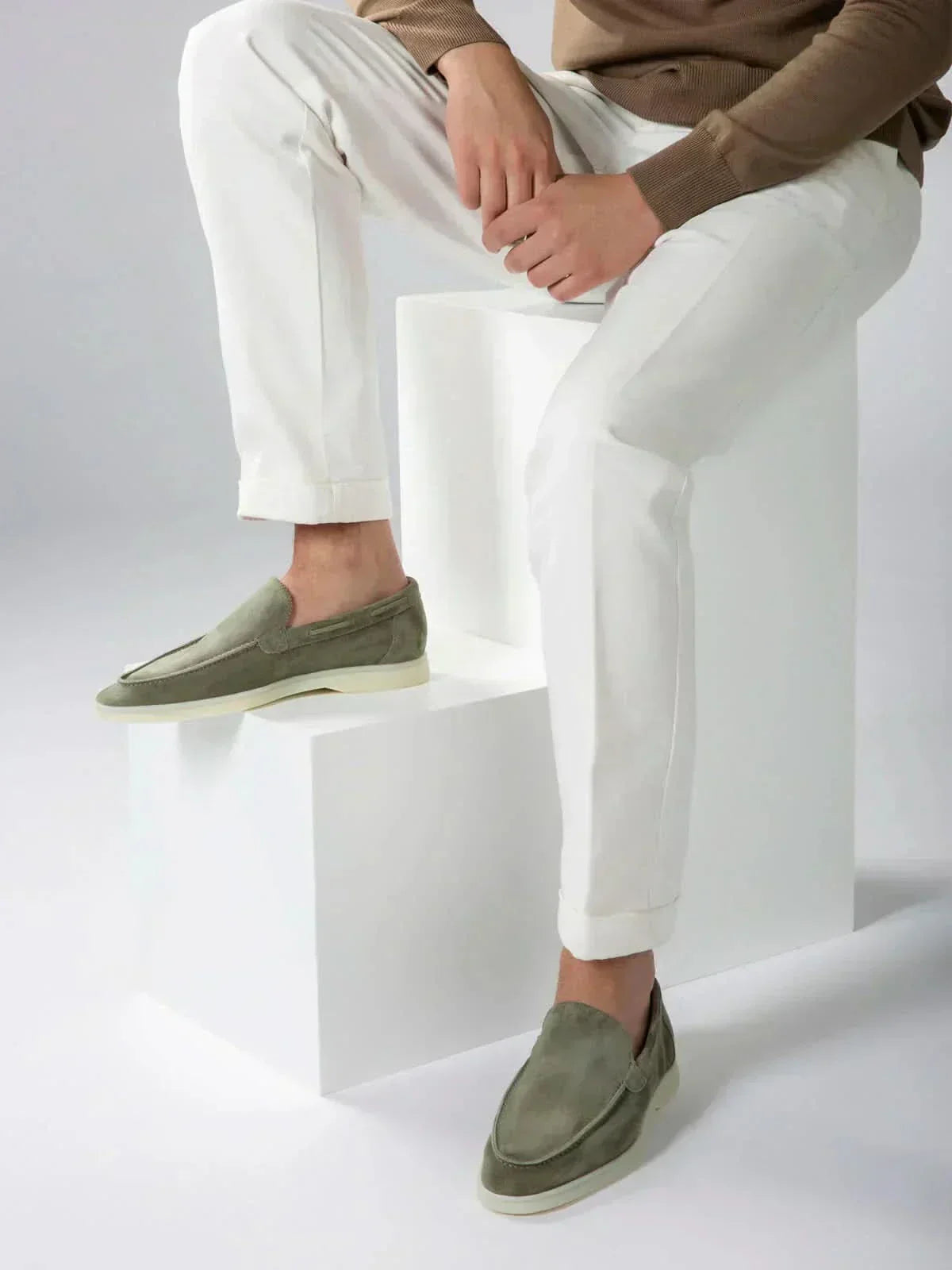 Mocasines de ante verde oliva, slip-on, con suela blanca.