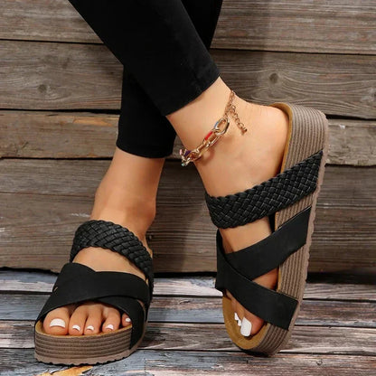 Sandalias ortopédicas negras con tiras trenzadas cruzadas y plataforma de cuña